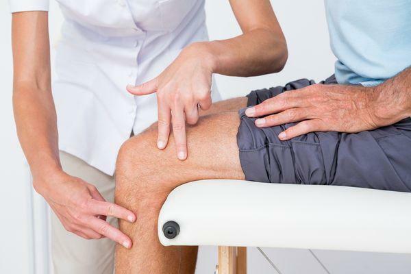 Examen de la articulación de la rodilla por un médico