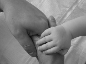 barnet håller sin mammas hand