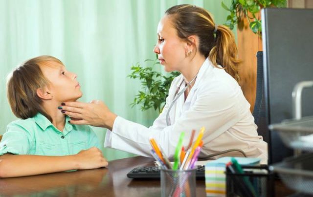 O médico verifica o crescimento da glândula tireoidea em uma criança