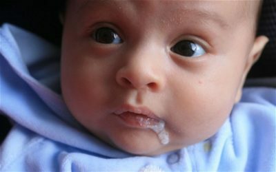 The baby belches coagulated milk with mucus, with a sour smell, after eating